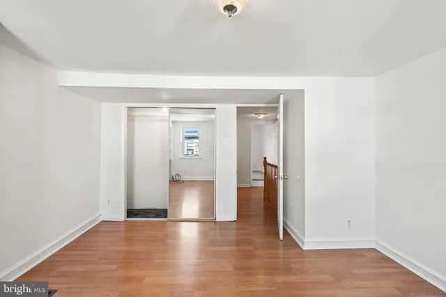 a view of empty room with wooden floor