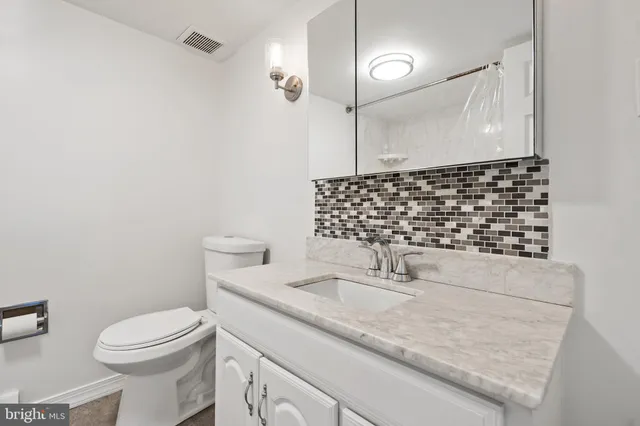 a bathroom with a sink a toilet and a mirror