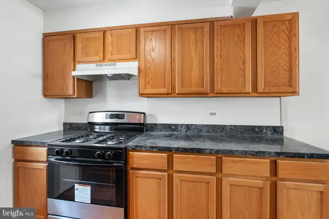 a kitchen with granite countertop stainless steel appliances a stove a sink and dishwasher