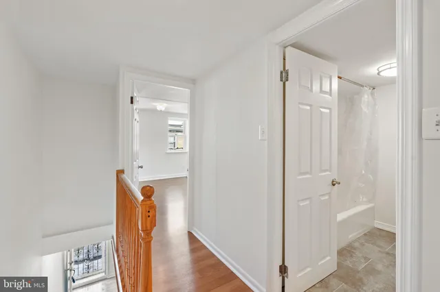 a view of a hallway with wooden floor and staircase