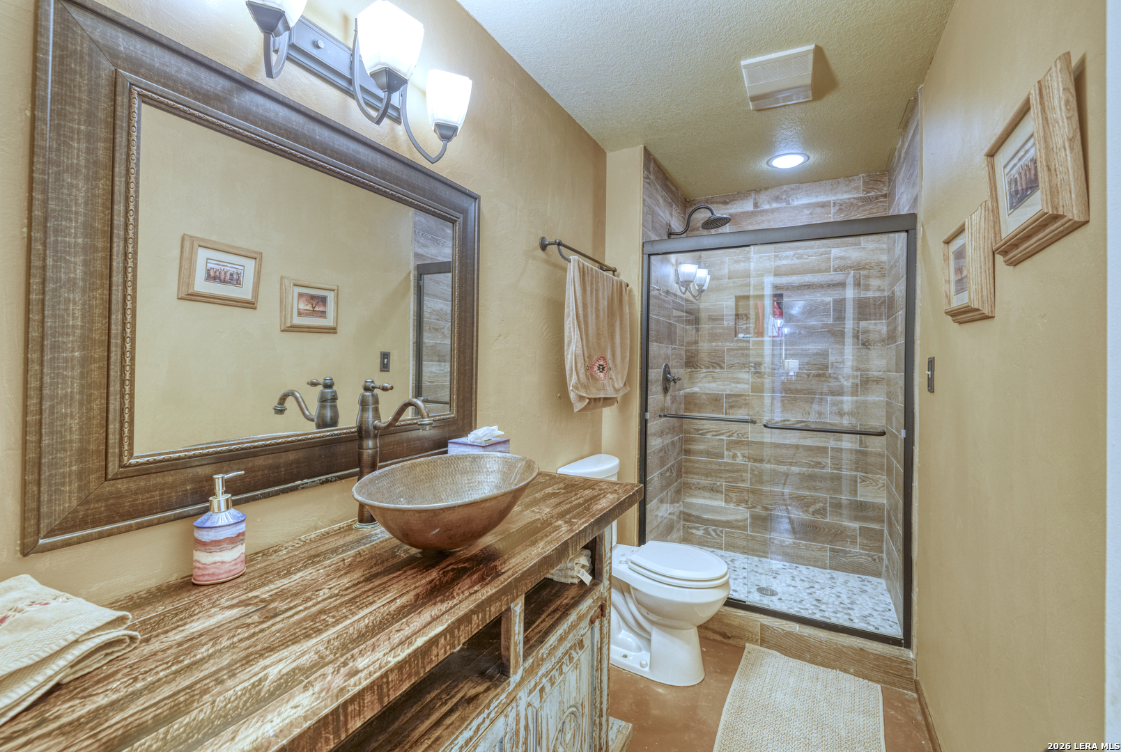 160 Beavers Trail Uvalde, TX 78801 - Photo 20 of 53 a bathroom with a granite countertop sink a toilet a mirror and shower