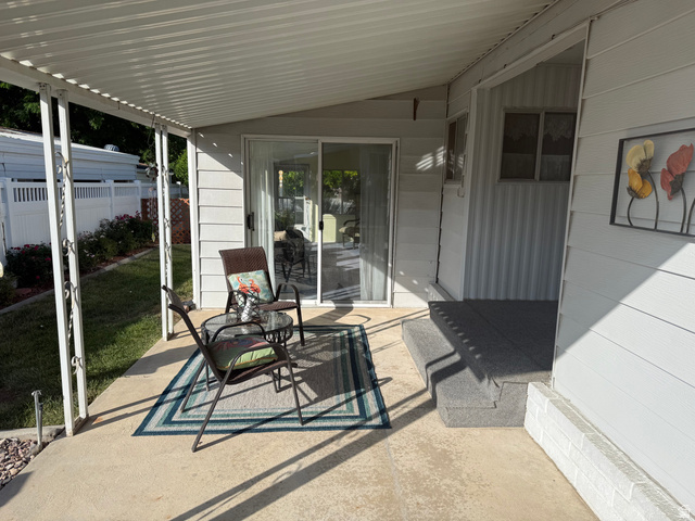 77 West Alta View Way Sandy, UT 84070 - Photo 23 of 43 Covered concrete patio with white support columns, white siding, and sliding glass door entry