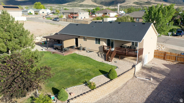1797 Sunset Road Enoch, UT 84721 - Photo 63 of 80 Rear exterior featuring a covered patio, a multi-level deck, and a green lawn