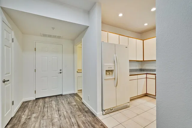 a view of a kitchen with a refrigerator and a sink