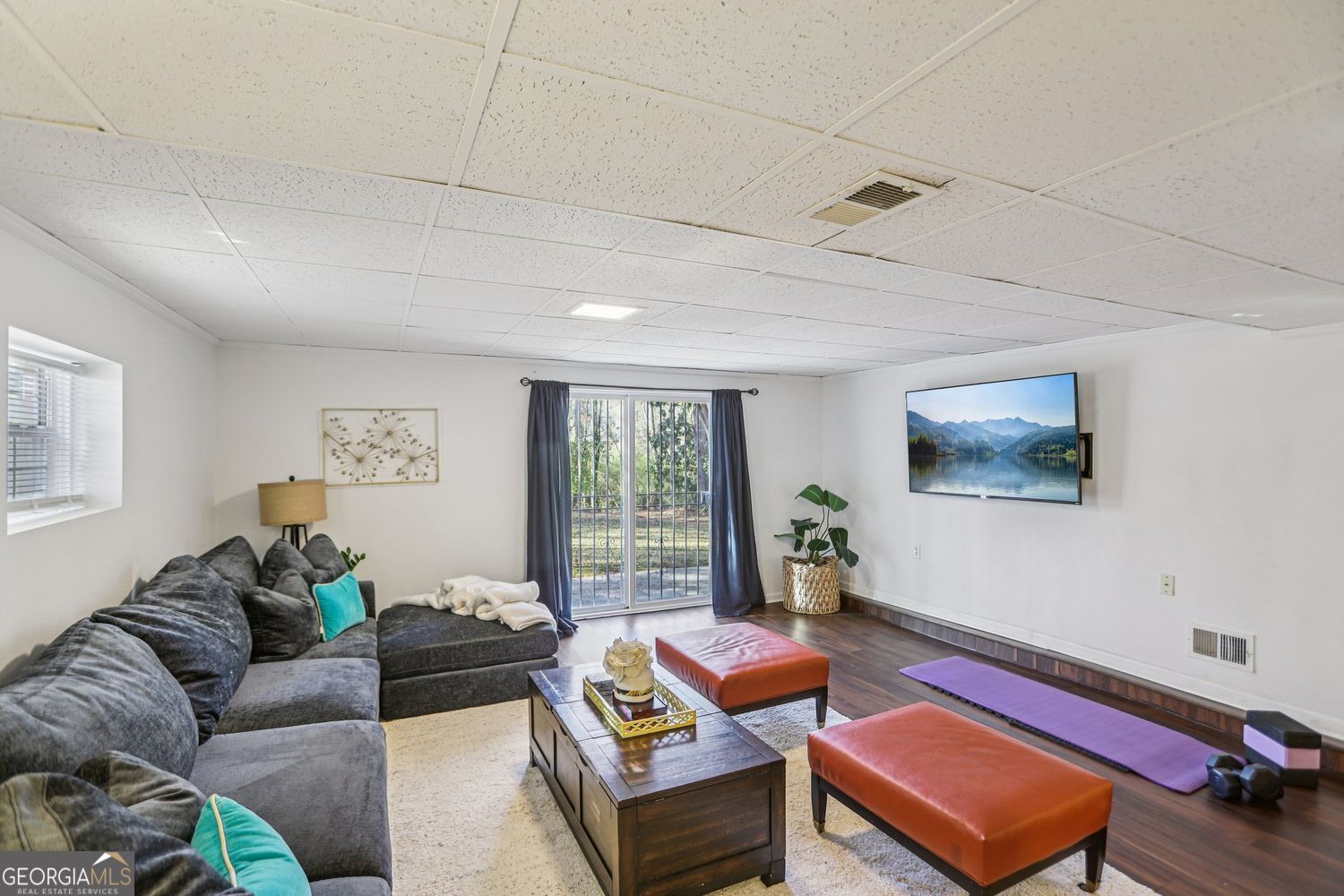 129 Tye Street Stockbridge, GA 30281 - Photo 18 of 27 a living room with furniture a large window and a flat screen tv