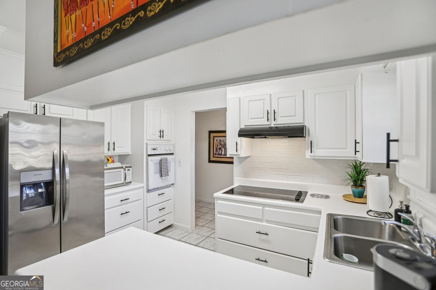 129 Tye Street Stockbridge, GA 30281 - Photo 7 of 27 a kitchen with white cabinets and stainless steel appliances