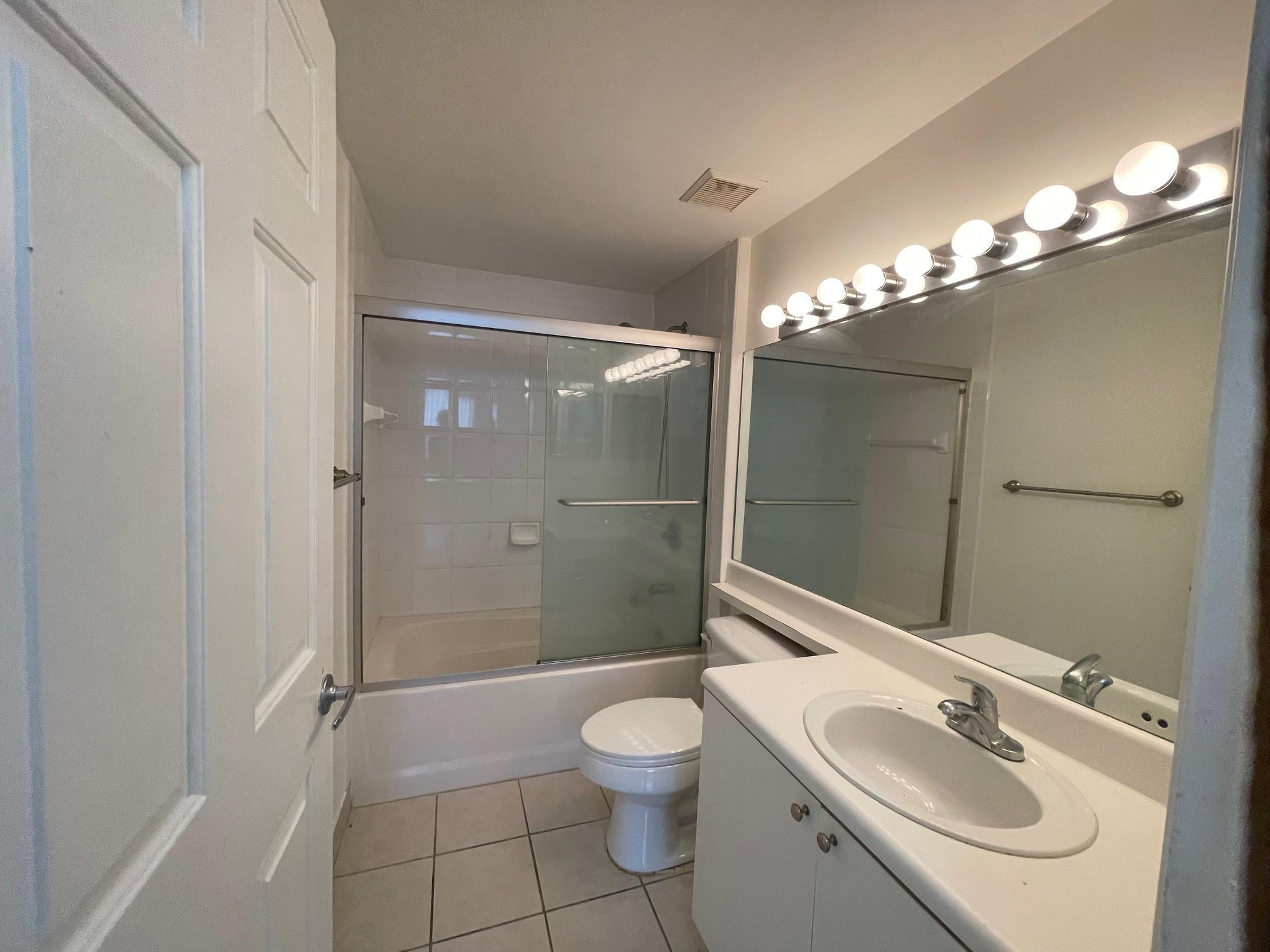 8010 North Nob Hill Road, Unit 205 Tamarac, FL 33321 - Photo 11 of 14 a bathroom with a sink toilet a shower and a mirror