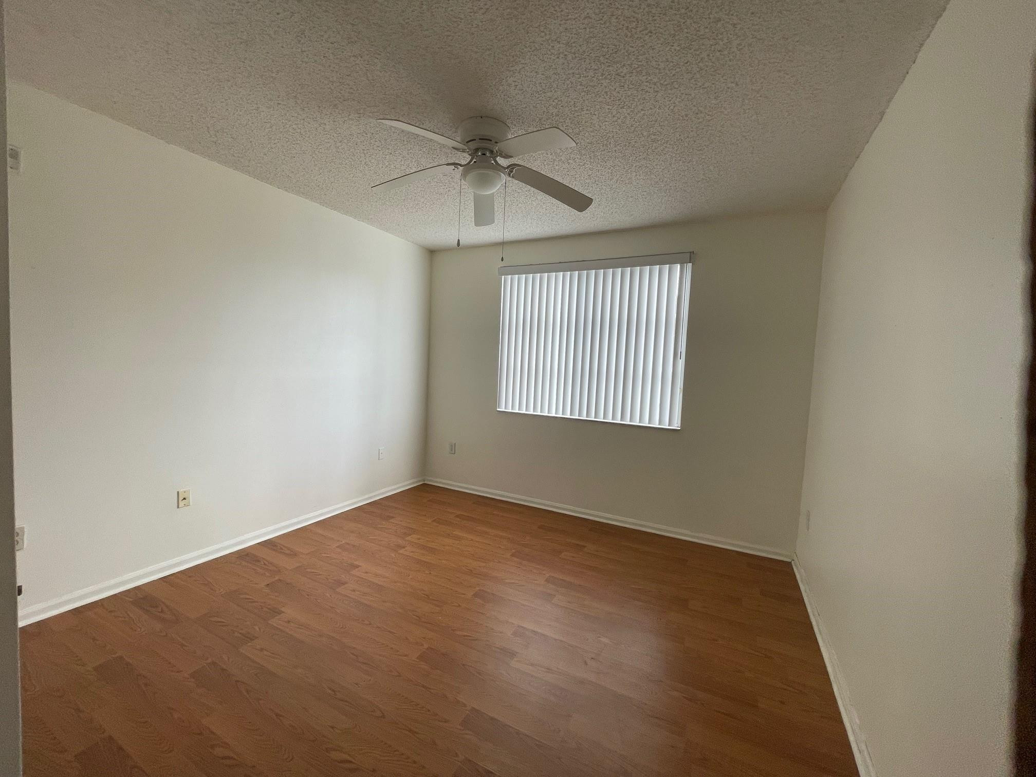 8010 North Nob Hill Road, Unit 205 Tamarac, FL 33321 - Photo 9 of 14 an empty room with windows and fan