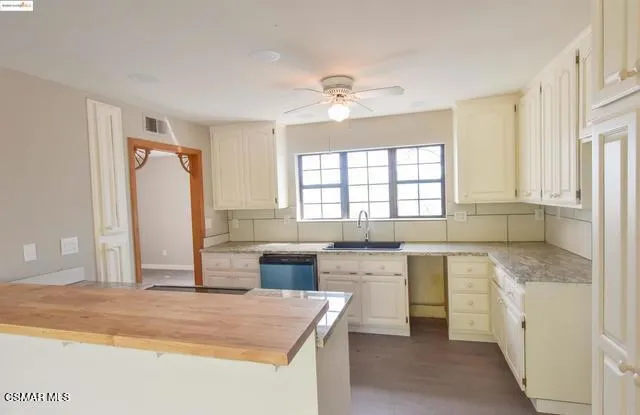 a large kitchen with granite countertop a sink stainless steel appliances and cabinets