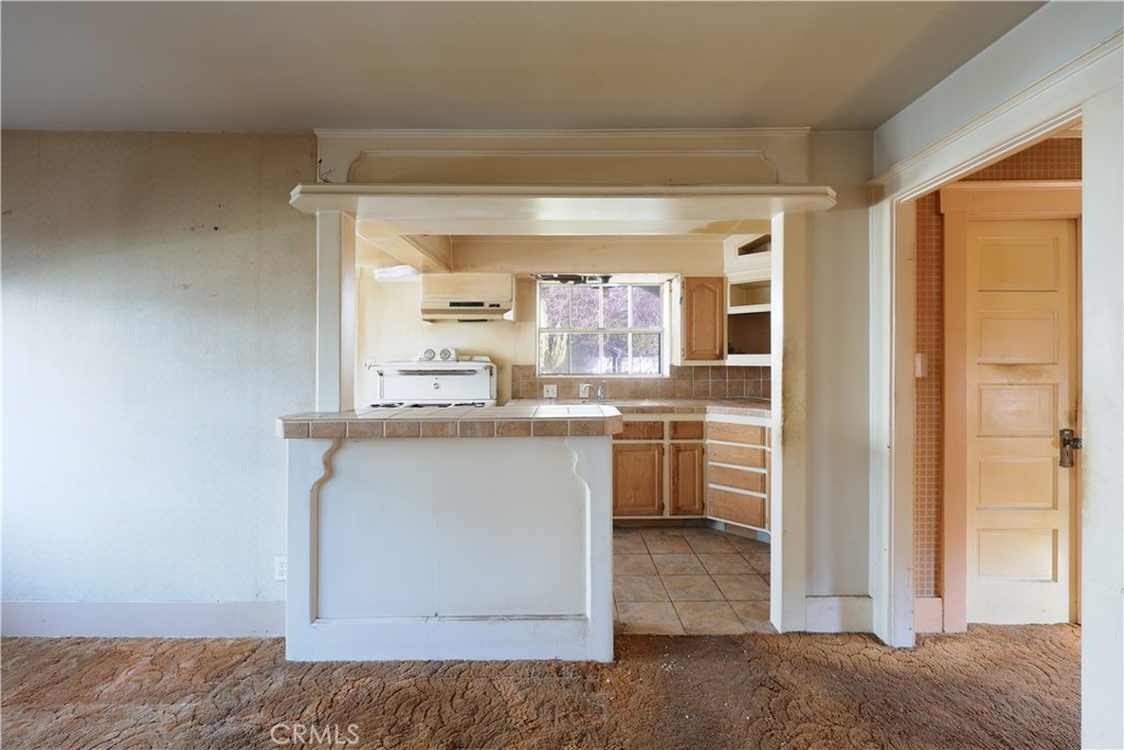 9211 Walnut Street Bellflower, CA 90706 - Photo 7 of 26 a room with kitchen island and white cabinets