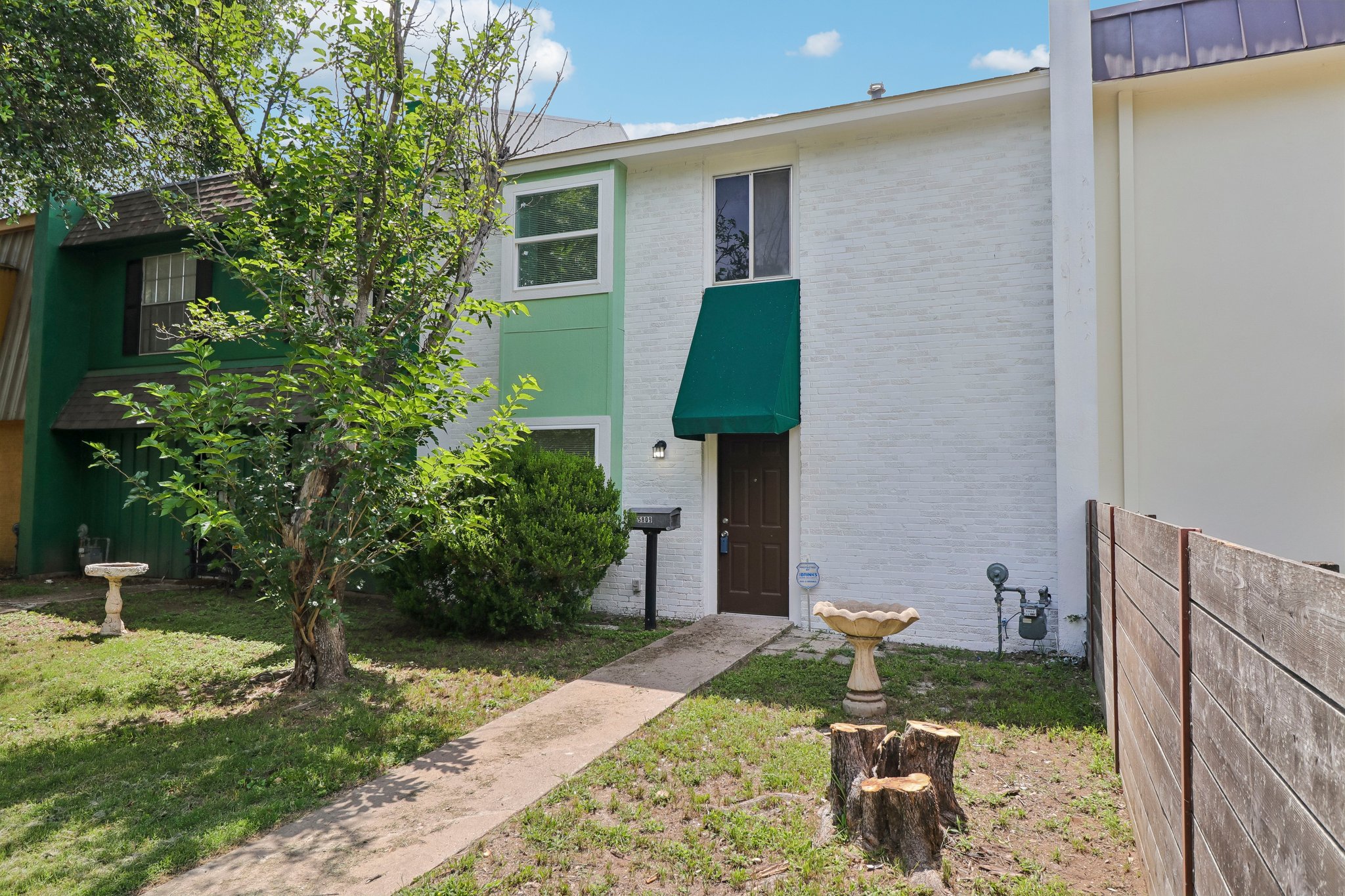 5809 Coventry Lane Austin, TX 78723 - Photo 2 of 35 A welcoming front entrance with an awning and mature landscaping offers charming curb appeal.