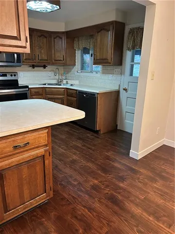 a kitchen with stainless steel appliances granite countertop a stove a sink and a microwave