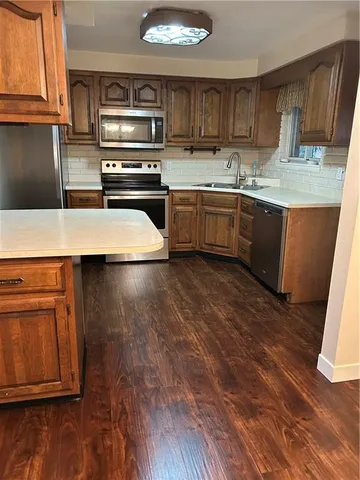 a view of a room that has a window and wooden floor