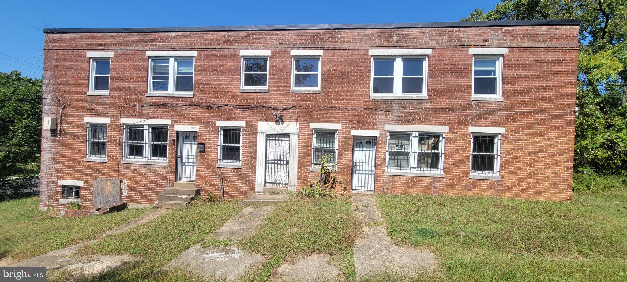 4962-4966 Benning Road Southeast Washington, DC 20019 - Photo 1 of 13 a front view of a house with a yard