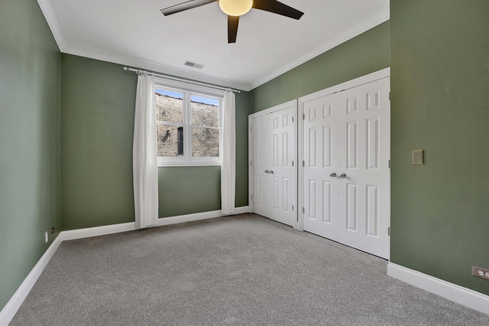 4543 North Malden Street, Unit 2N Chicago, IL 60640 - Photo 11 of 25 an empty room with chandelier fan and windows