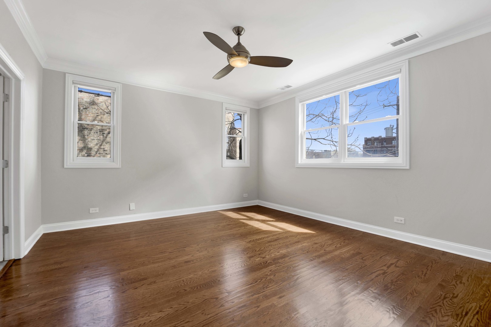 4543 North Malden Street, Unit 2N Chicago, IL 60640 - Photo 15 of 25 a view of an empty room with wooden floor and a ceiling fan