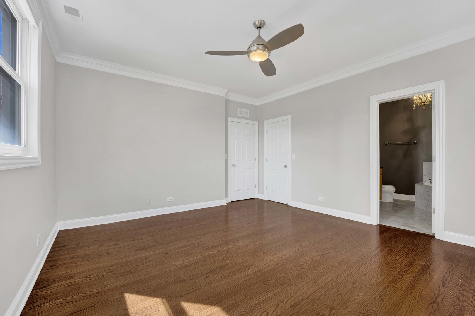 4543 North Malden Street, Unit 2N Chicago, IL 60640 - Photo 17 of 25 an empty room with wooden floor and ceiling fan