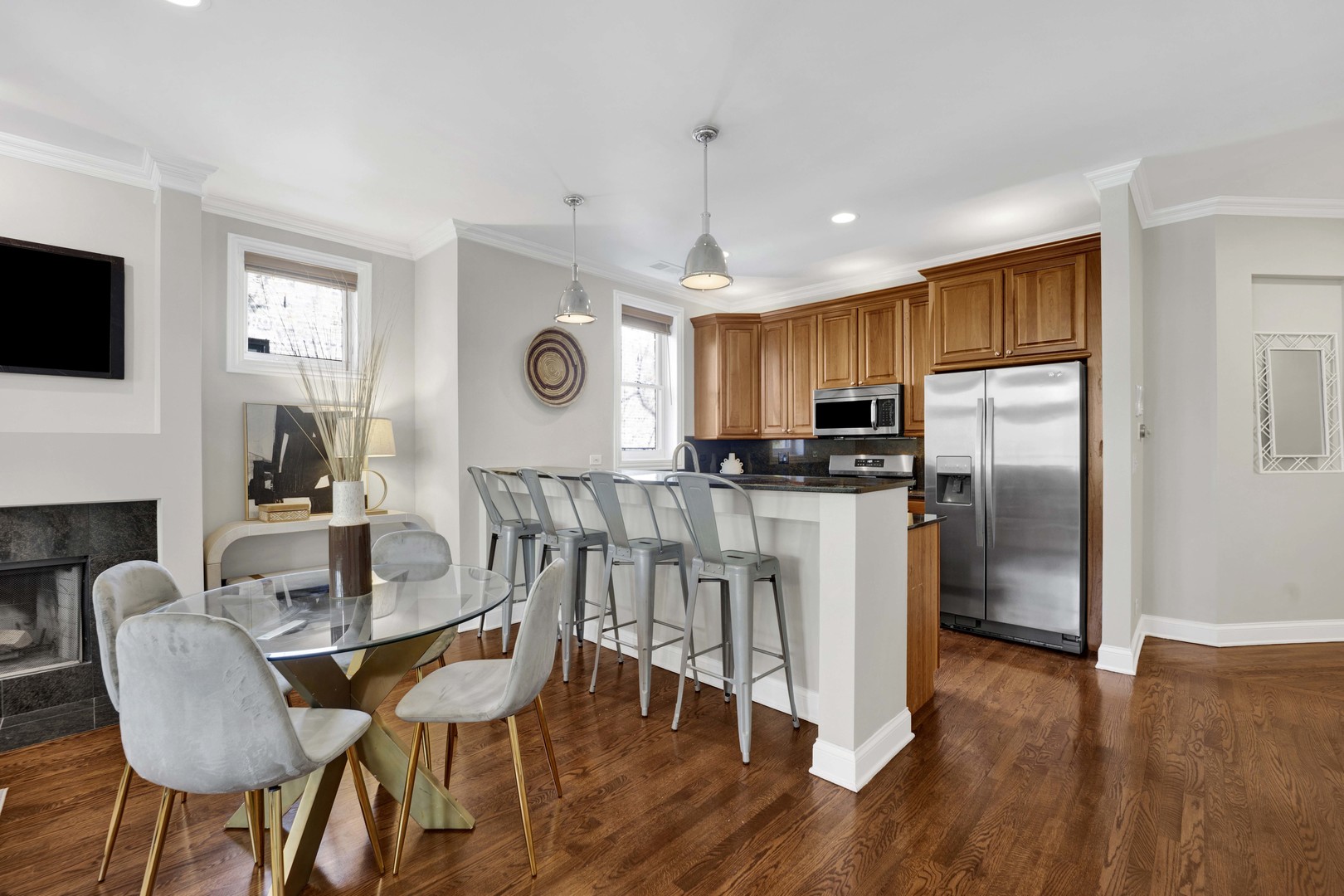 4543 North Malden Street, Unit 2N Chicago, IL 60640 - Photo 7 of 25 a kitchen with stainless steel appliances granite countertop a stove a refrigerator a kitchen island a dining table and chairs with wooden floor