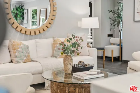 a living room with furniture a lamp a potted plant and a large window