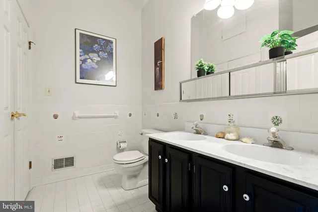 a bathroom with a sink a potted plant and a mirror