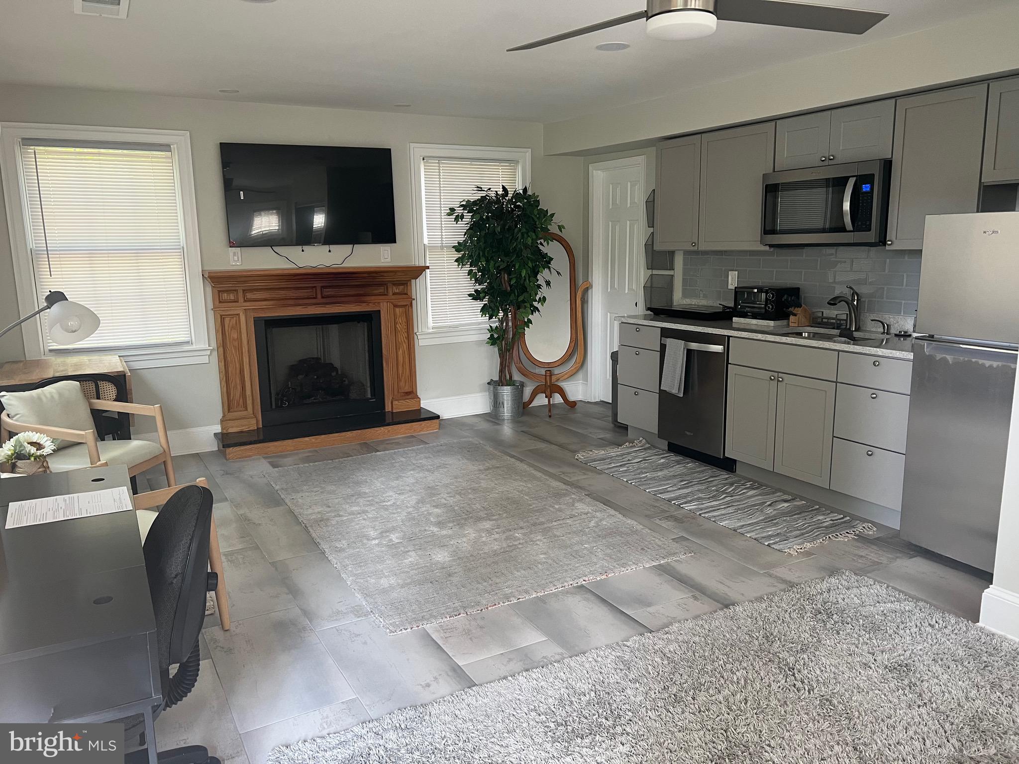 a living room with furniture a flat screen tv and a fireplace