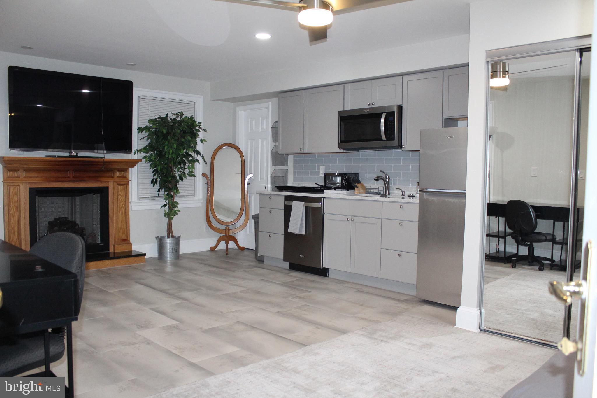 7703 Newcastle Drive Annandale, VA 22003 - Photo 6 of 12 a living room with furniture a flat screen tv and a fireplace
