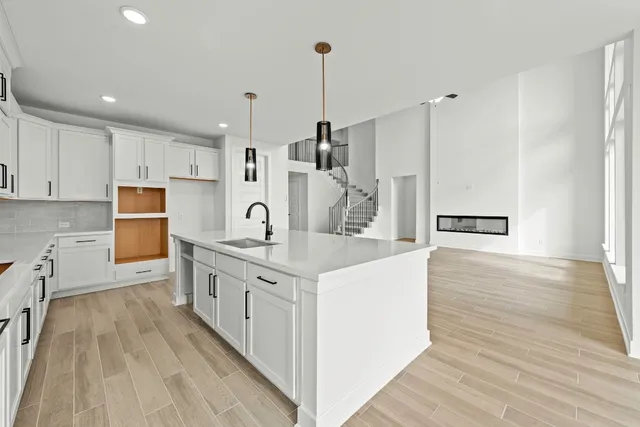 a kitchen with white cabinets appliances and wooden floor