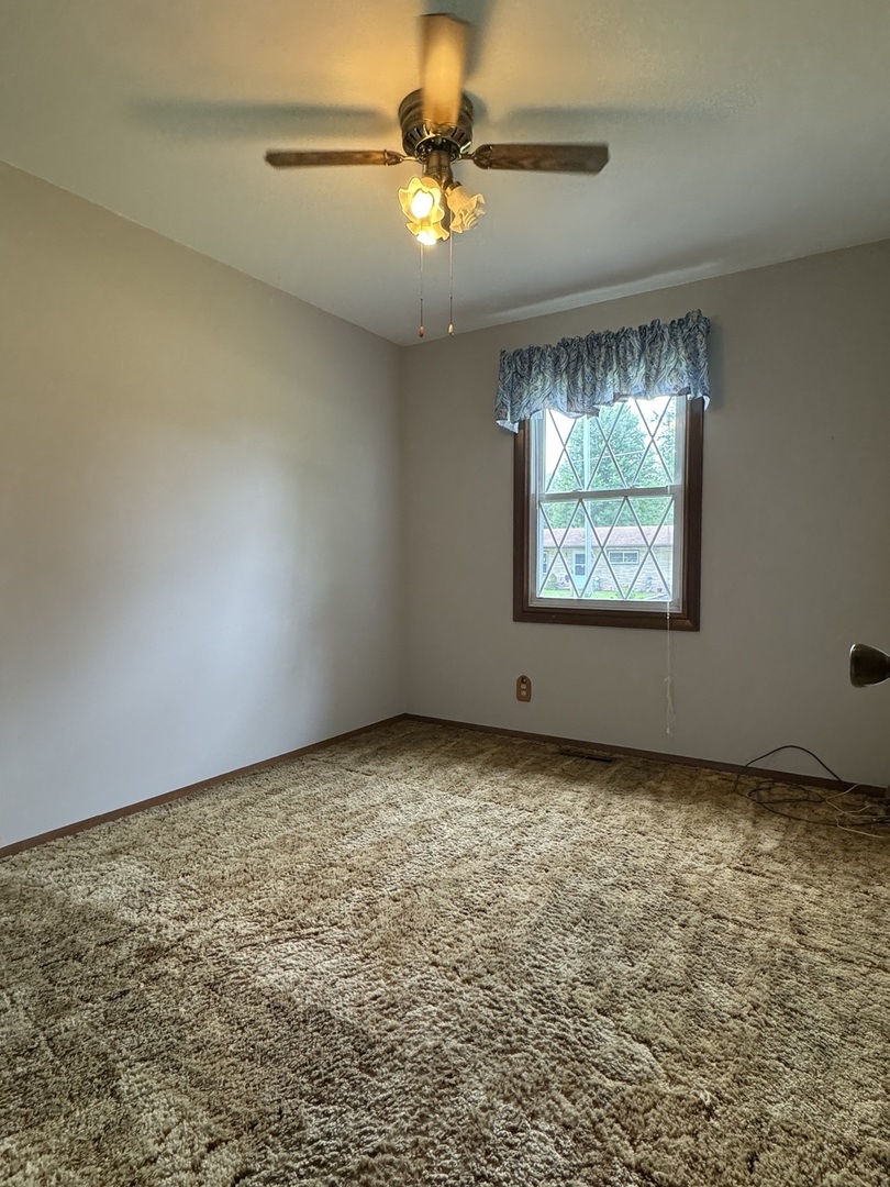 7912 Elm Street Harvard, IL 60033 - Photo 11 of 37 an empty room with a window and a fan