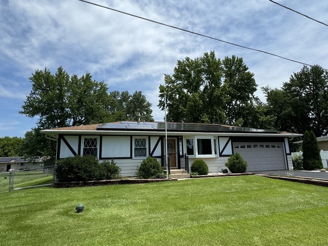 7912 Elm Street Harvard, IL 60033 - Photo 2 of 37 a front view of house with a garden and trees