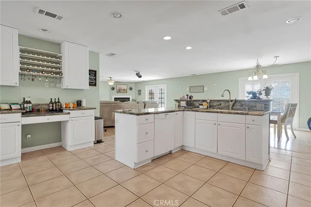 a kitchen with white cabinets appliances and a sink