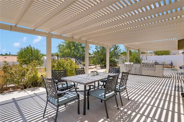 a view of a patio with table and chairs and potted plants