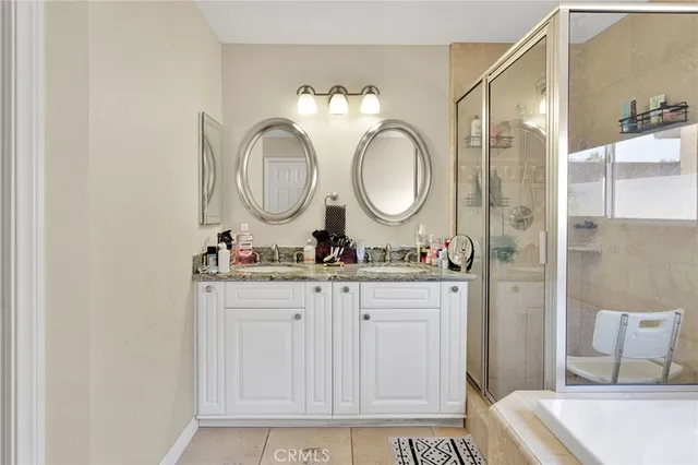 a bathroom with a granite countertop sink mirror and a shower