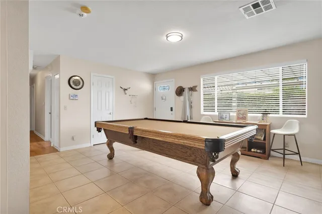 a room with pool table and windows