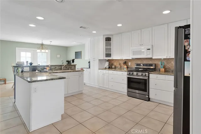 a kitchen with granite countertop white cabinets and stainless steel appliances