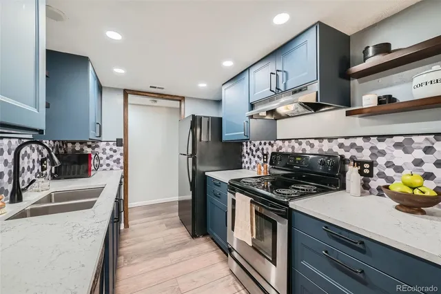 a kitchen with stainless steel appliances granite countertop a sink and a stove