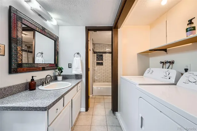a en suite bathroom with a granite countertop sink and a mirror