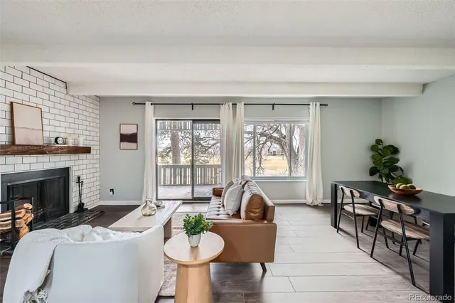 a living room with furniture a fireplace and a potted plant