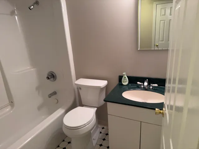 a white toilet sitting next to a bathroom sink