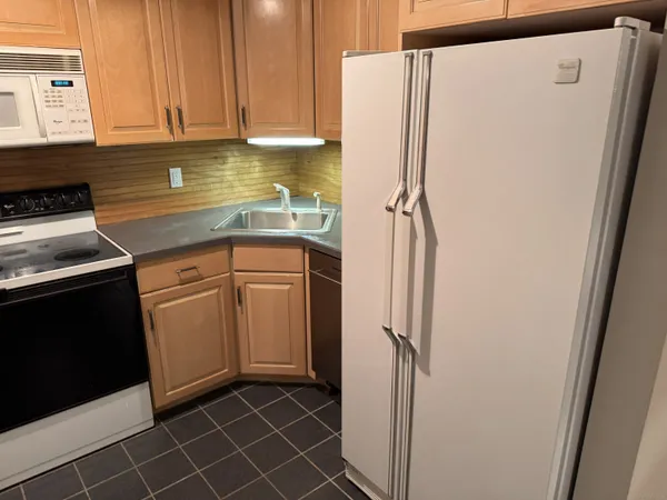 a kitchen with a refrigerator sink and cabinets