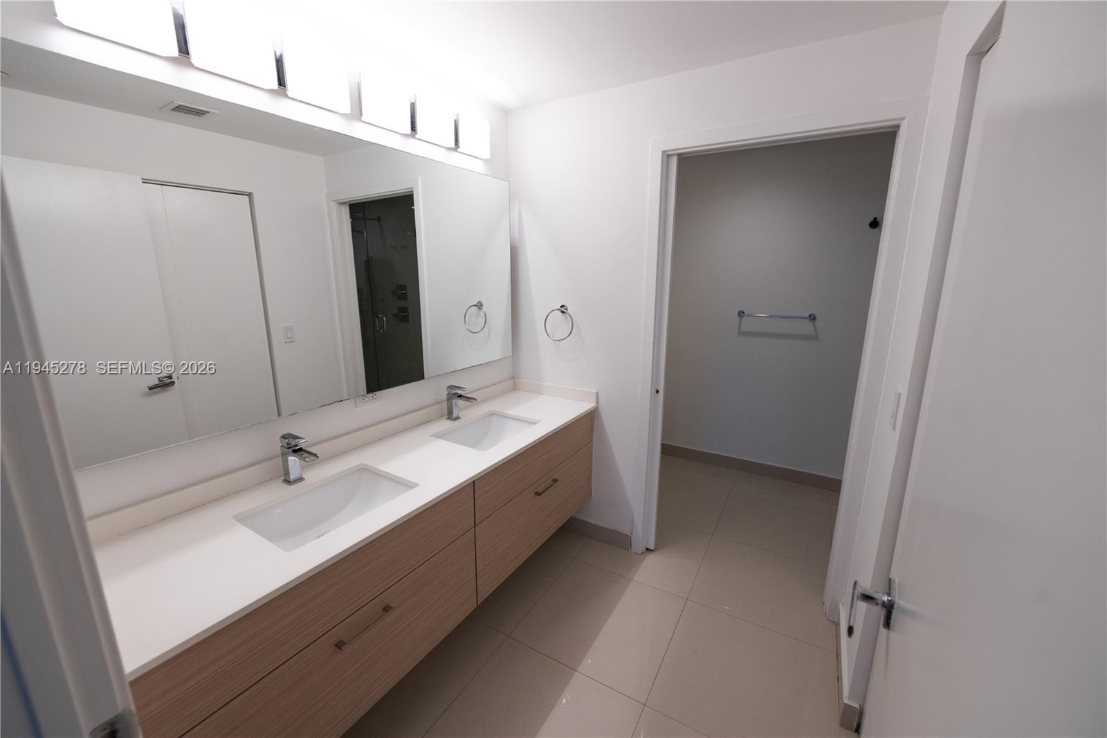 600 Northeast 27th Street, Unit 1602 Miami, FL 33137 - Photo 19 of 34 a bathroom with a double vanity sink and mirror