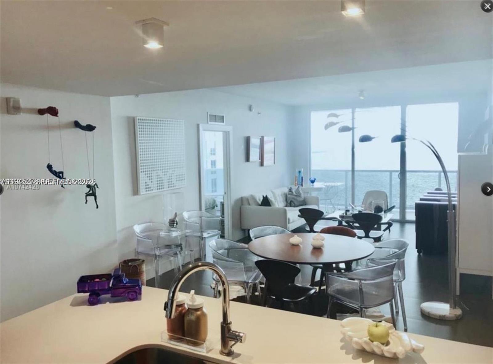 600 Northeast 27th Street, Unit 1602 Miami, FL 33137 - Photo 32 of 34 a dining room with furniture and wooden floor