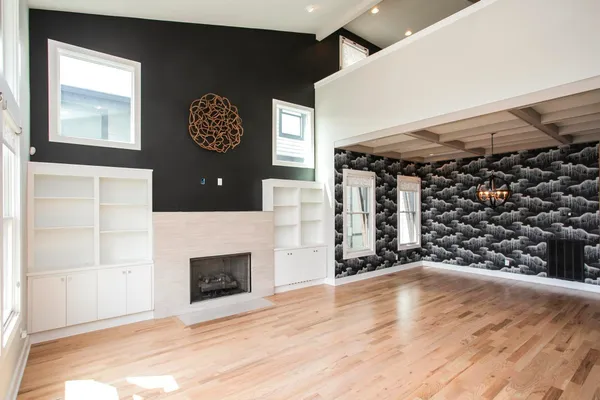 a view of an empty room with a fireplace and a window