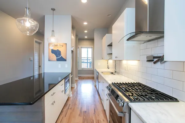 a large white kitchen with a large window