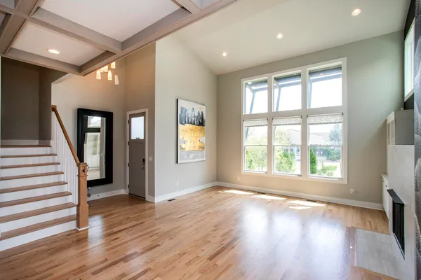 a view of an empty room with a fireplace and wooden floor