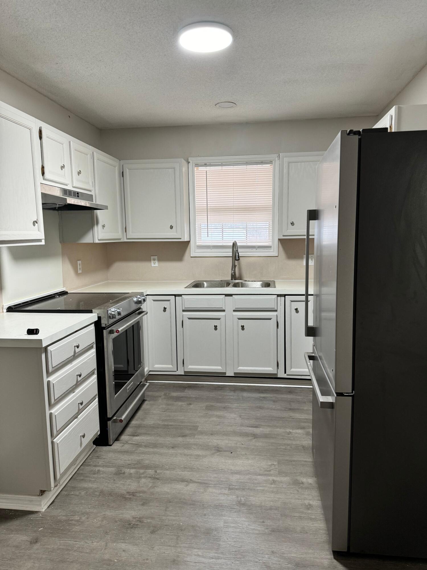 4411-2 Kemper Street Lubbock, TX 79416 - Photo 3 of 14 a kitchen with stainless steel appliances granite countertop a stove a sink and a refrigerator