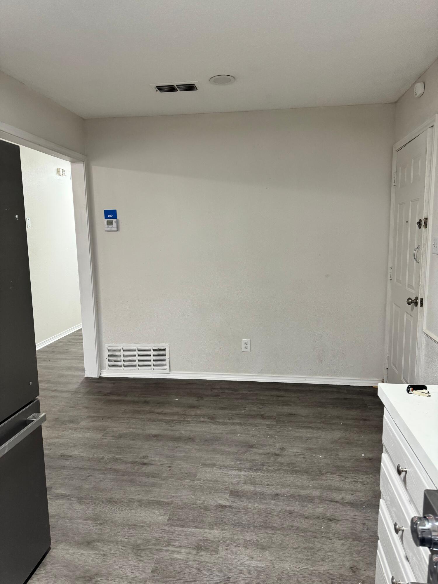 4411-2 Kemper Street Lubbock, TX 79416 - Photo 5 of 14 a view of an empty room with wooden floor and a window