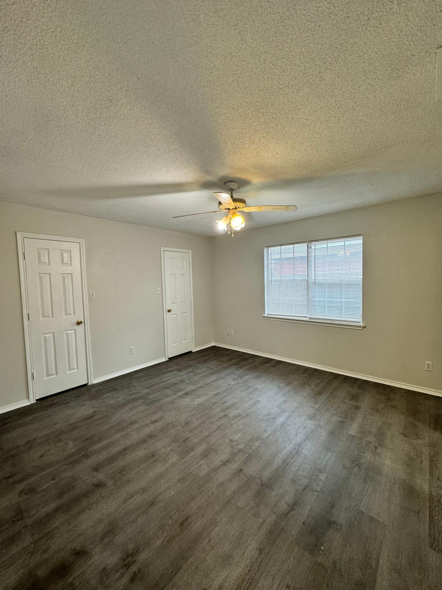 4411-2 Kemper Street Lubbock, TX 79416 - Photo 10 of 14 an empty room with wooden floor and windows
