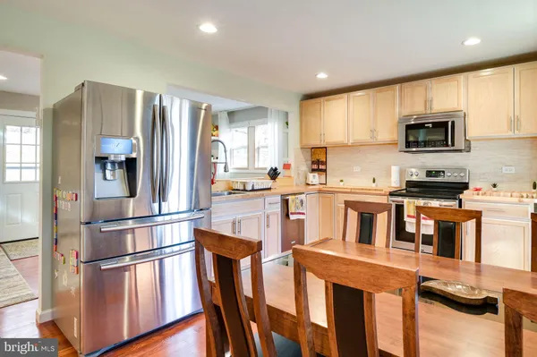 a kitchen with stainless steel appliances granite countertop a refrigerator a stove top oven a sink and dishwasher