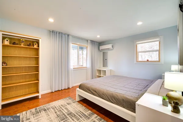 a bedroom with a bed and wooden floor