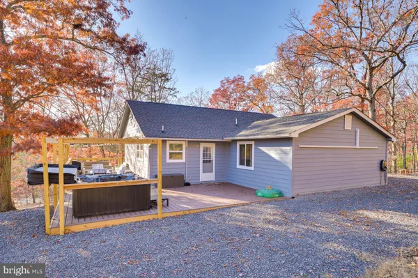 a view of a house with a yard and large tree